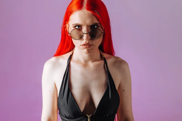 Retrato de una chica con el pelo rojo y gafas redondas en un bac rosa — Foto de Stock