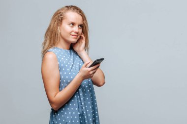 Telefonu tutan ve kablosuz kafada müzik dinleyen kız