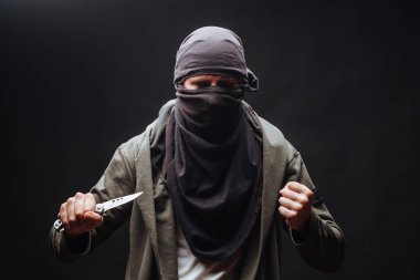 koyu arka plan üzerinde bıçak ve maske ile adam