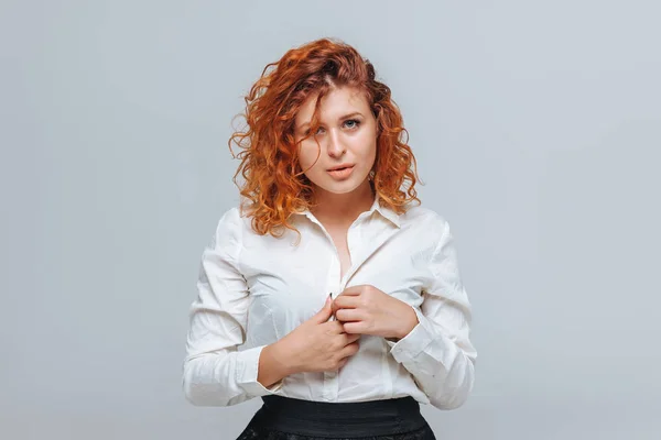 Red-haired girl sexy unbuttons his shirt — Stock Photo, Image