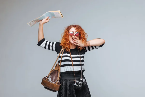 Chica turista pelirroja con un mapa, binoculares y mochila en un — Foto de Stock