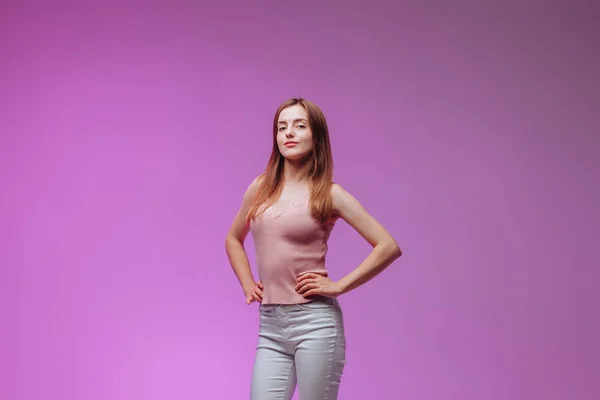 紫色の背景にピンクのTシャツを着た少女の肖像 — ストック写真