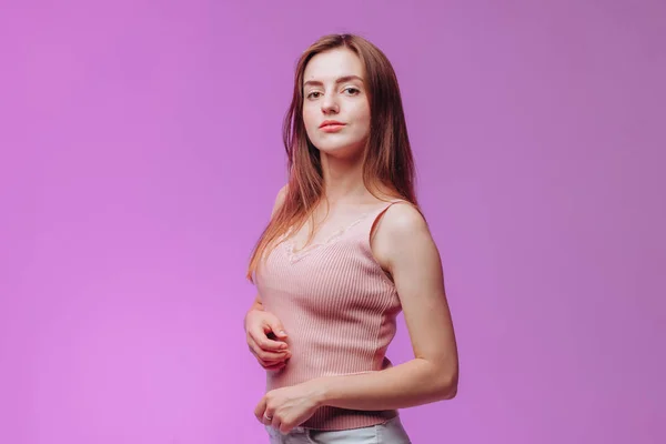 Retrato de una chica con una camiseta rosa sobre un fondo morado —  Fotos de Stock