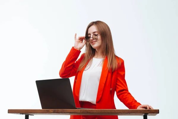 Seksowna dziewczyna w czerwonej kurtce pracując przy komputerze na białym BAC — Zdjęcie stockowe