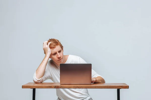 Ein Mann arbeitet an einem Laptop auf hellem Hintergrund — Stockfoto
