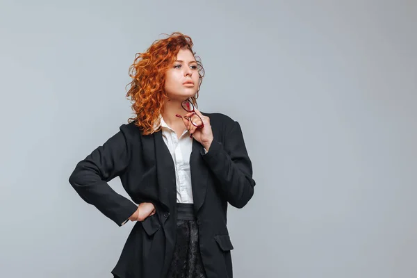 Una mujer pelirroja en traje de negocios y gafas — Foto de Stock