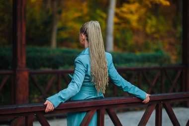 Autumn Park 'ın arka manzarasında birden fazla ince örgülü kız.