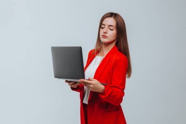 kırmızı ceketli kız hafif bir arka plan üzerinde bir dizüstü tutar