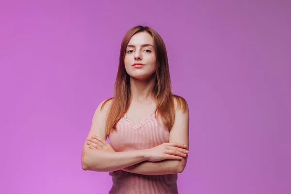 Chica cruzó sus brazos contra el fondo rosa — Foto de Stock