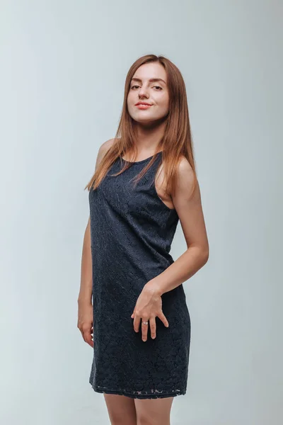 Girl in a dark dress posing on a gray background — Stock Photo, Image