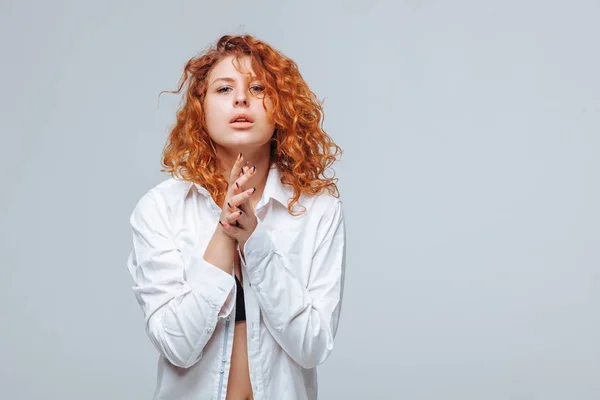 Red-haired girl in a white shirt on a light gray background — Stock Photo, Image