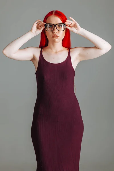 Dívka s červenými dlouhými vlasy se dotýká brýlí — Stock fotografie