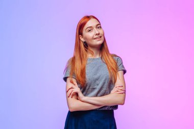 Kızıl saçlı kollarını kavuşturur ve gülümser.