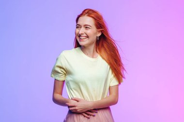 Pembe-mor arka planda gülümseyen kızıl saçlı kız