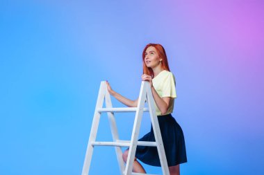 Kızıl saçlı kız merdivenin başında dikiliyor. Kavram başarısı