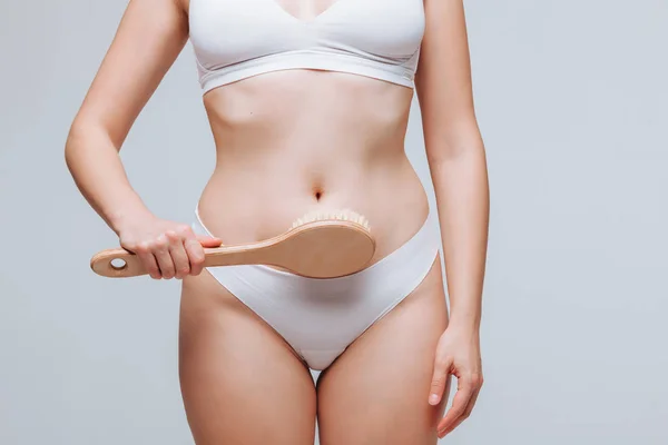 Mujer haciendo masaje en su estómago cepillo anti celulitis — Foto de Stock