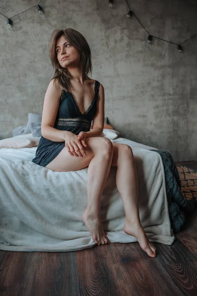 Lány szép lábak ül az ágyon — Stock Fotó