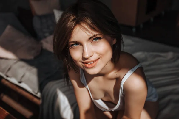 Porträt eines netten Mädchens am Morgen am Fenster auf dem Bett — Stockfoto