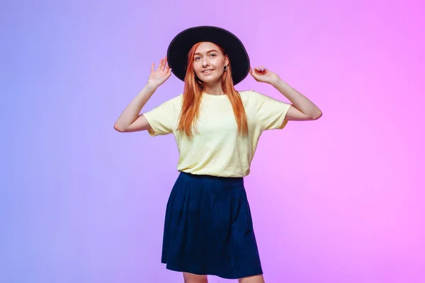 Pelirroja chica en sombrero toca en un fondo de color —  Fotos de Stock