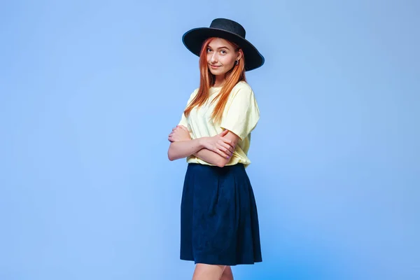 Chica pelirroja en el sombrero cruzó los brazos contra el bac azul — Foto de Stock