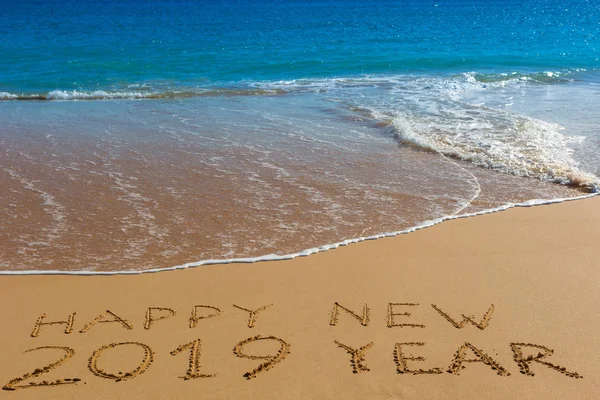 快乐新的2019一年题词写在潮湿的黄色沙滩沙子 庆祝新年的概念 — 图库照片