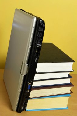 Dizüstü bilgisayar ile kitap tarafında yığını