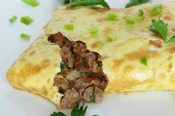 Doldurulmuş bir Tay omlet beyaz plaka üzerinde     