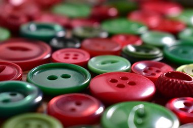 ahşap bir masa üstünde yeşil ve kırmızı dikiş düğme