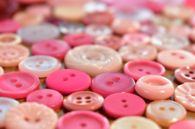 ahşap bir masa üstünde parlak pembe dikiş düğme