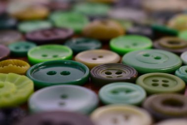 ahşap bir masa üzerindeki yeşil dikiş düğmeleri