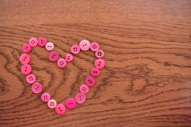 Mor ve pembe dikiş düğmeleri ahşap üzerine