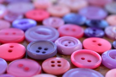 Mor ve pembe dikiş düğmeleri ahşap üzerine