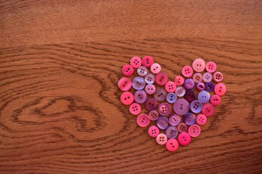 Mor ve pembe dikiş düğme kalp ahşap üzerine