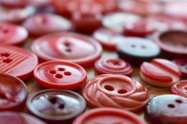 ahşap bir masa üzerinde kırmızı dikiş buttens