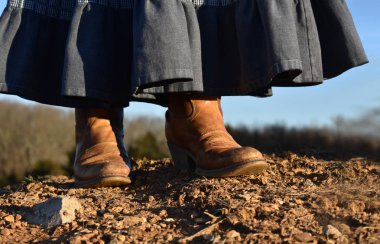 bir kadın bir kot etek ve kovboy çizmeleri yürüyüş
