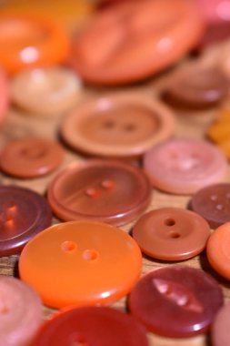 ahşap bir masa üzerindeki turuncu dikiş düğmeleri