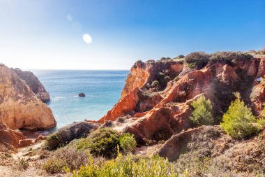 Kırmızı kayalar ve Portekiz, Atlantik kıyısında mavi deniz Algarve bölgesi, güzel çarpıcı aydınlık yatay