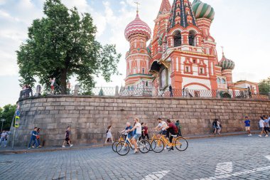 Moscow, Russia. June, 18, 2018. Tourists ride bicycles along Red Square overlooking the Cathedral of St. Basil the Blessed clipart