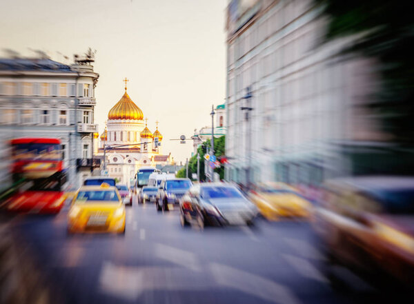 Улица с движущимися автомобилями в Москве, Россия, городской фон, с видом на Храм Христа Спасителя
