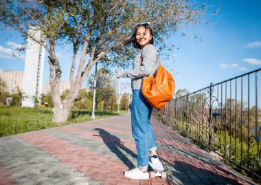 Güzel Asyalı kız 15-16 yaşında, kaykay, eğlence ve kız öğrenci geri kalanı üzerinde millenial genç