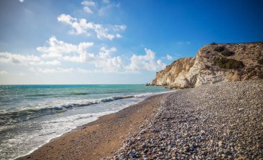Güzel sahne, bir taş çakıl plaj, mavi deniz dalgaları ve kayalar, Kıbrıs ziyareti