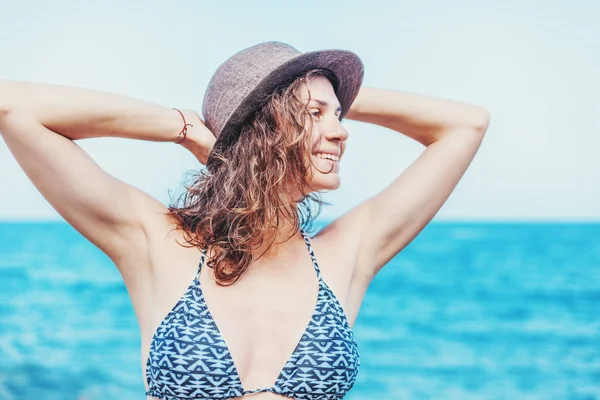 夏の休日や休暇コンセプト ビーチでビキニと麦わら帽子立っているの幸せな笑顔の女の子 — ストック写真