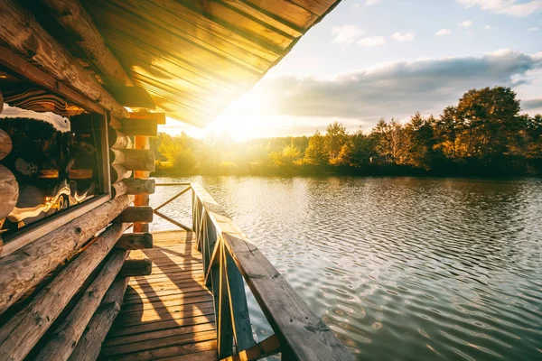 木房子的阳台上水在湖 在日落时 一条美丽的河银行在日落时 — 图库照片