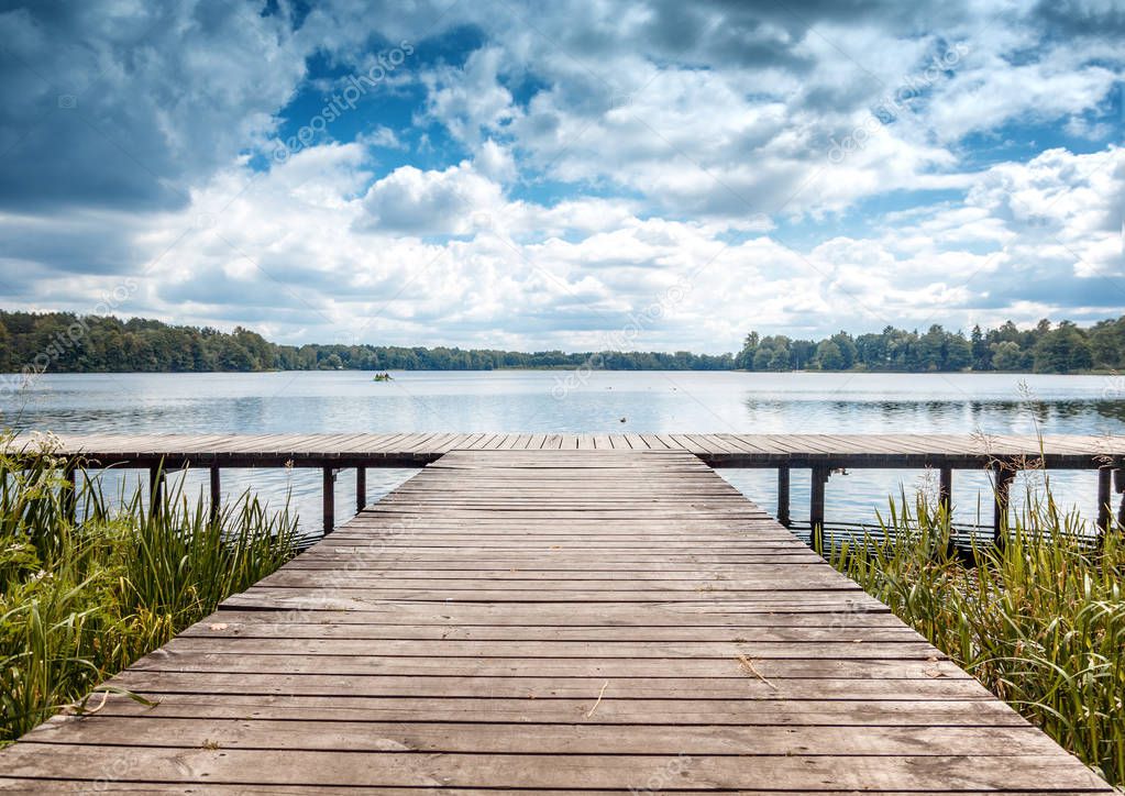 Beautiful summer landscape with dramatic sky, wooden pier on the lake, Trakai, Lithuania