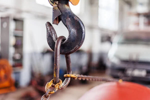 The load hangs on an old rusty iron hook, transportation, loading of goods, repair concept