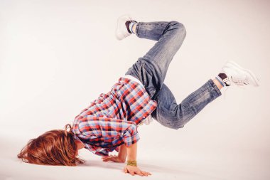 Genç güzel kadın unsuru breakdance hafif bir arka plan üzerinde hip hop dans yapıyor