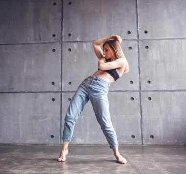 Genç güzel kadın üst ve kot modern çağdaş dans stüdyosu, çağdaş sanat, beden ve ruh, profesyonel dansçı uyum içinde dans