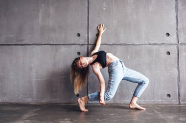 Genç güzel kadın üst ve kot modern çağdaş dans stüdyosu, çağdaş sanat, beden ve ruh, profesyonel dansçı uyum içinde dans