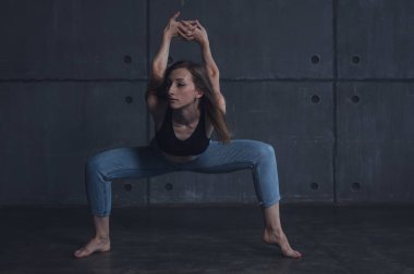 Genç güzel kadın üst ve kot modern çağdaş dans stüdyosu, çağdaş sanat, beden ve ruh, profesyonel dansçı uyum içinde dans