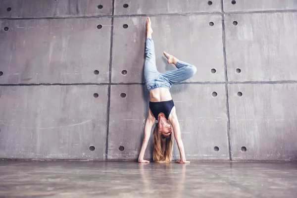 若くてきれいな女性プロのダンサーのダンス スタジオの床の壁にもたれて逆立ち — ストック写真